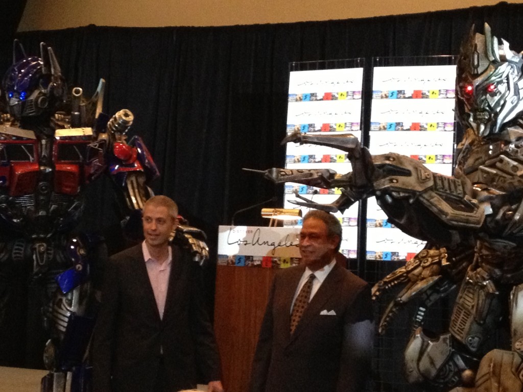 Thomas See, vice-president, sales & marketing, Universal Studios Hollywood (left) and Ernest Wooden Jr., president & CEO, Los Angeles Tourism & Convention Board (right) pose with Transformers.