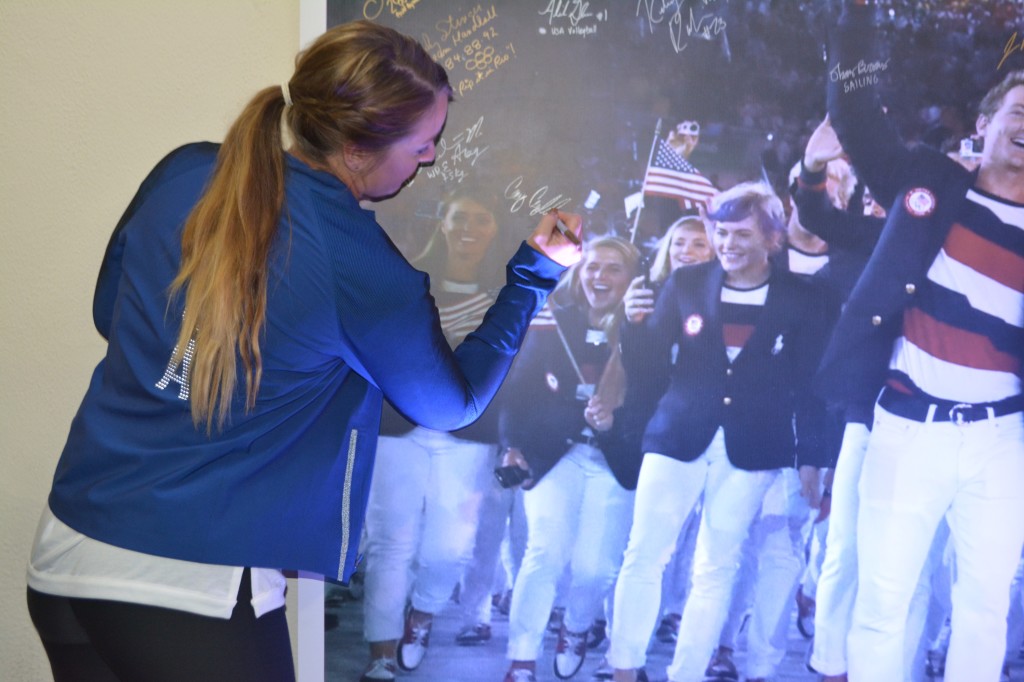 Bronze medalist in shooting Corey Cordell signs her name to the photo from the Opening Ceremony.