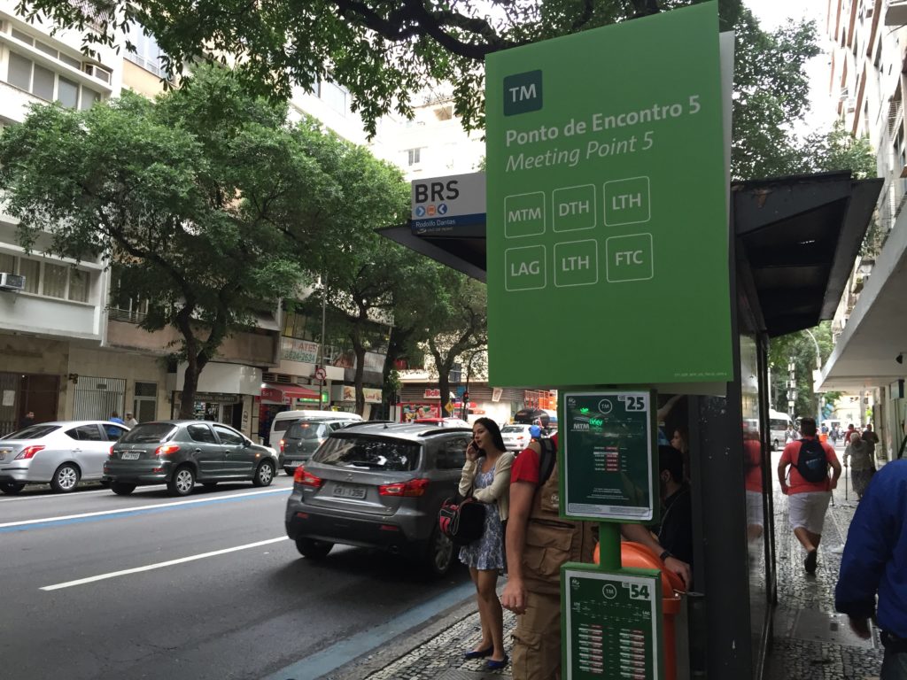 Signage indicating a Rio bus stop is also a stop within the credentialed transportation system.