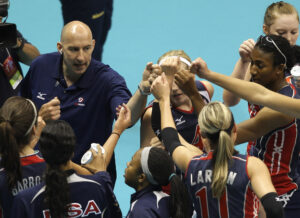 Hugh McCutcheon, top left, head coach of the US women's national volleyball team, bumps fists with players during a World Grand Prix volleyball game against Germany in Rio de Janeiro. McCutcheon is now the secretary general of the FIVB, the international federation. (AP Photo/Silvia Izquierdo, File)